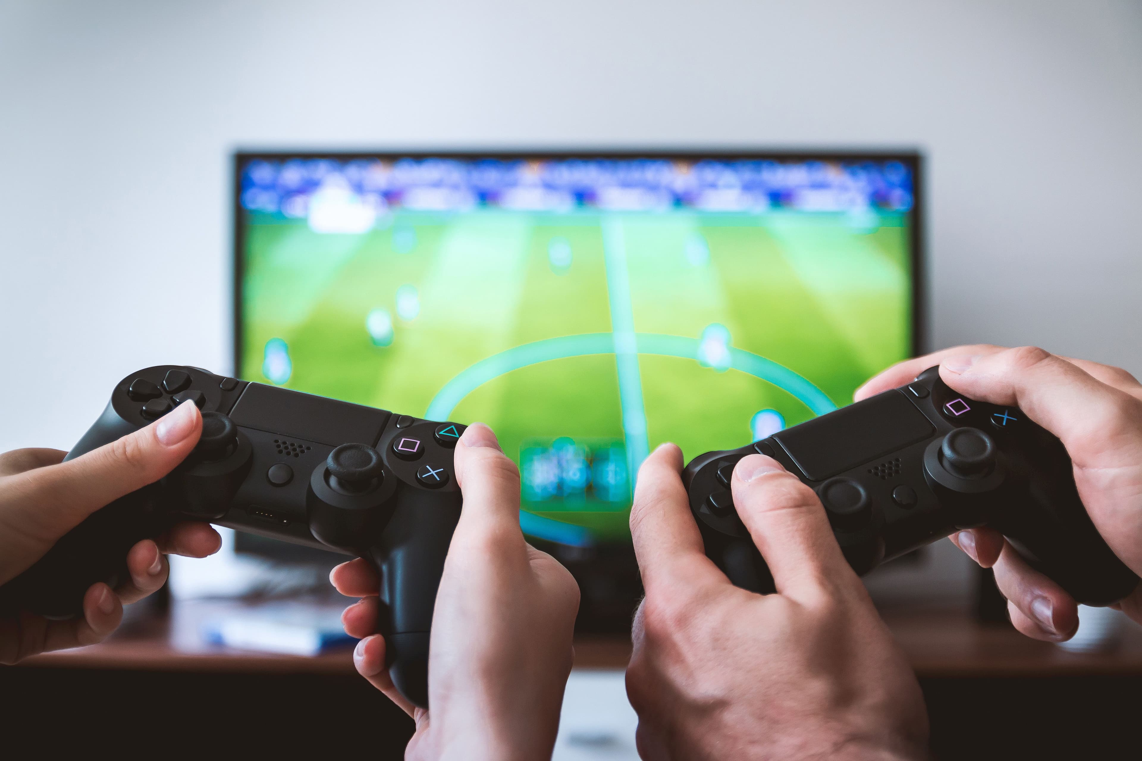 Person holding a remote control in front of a large TV displaying streaming content underground