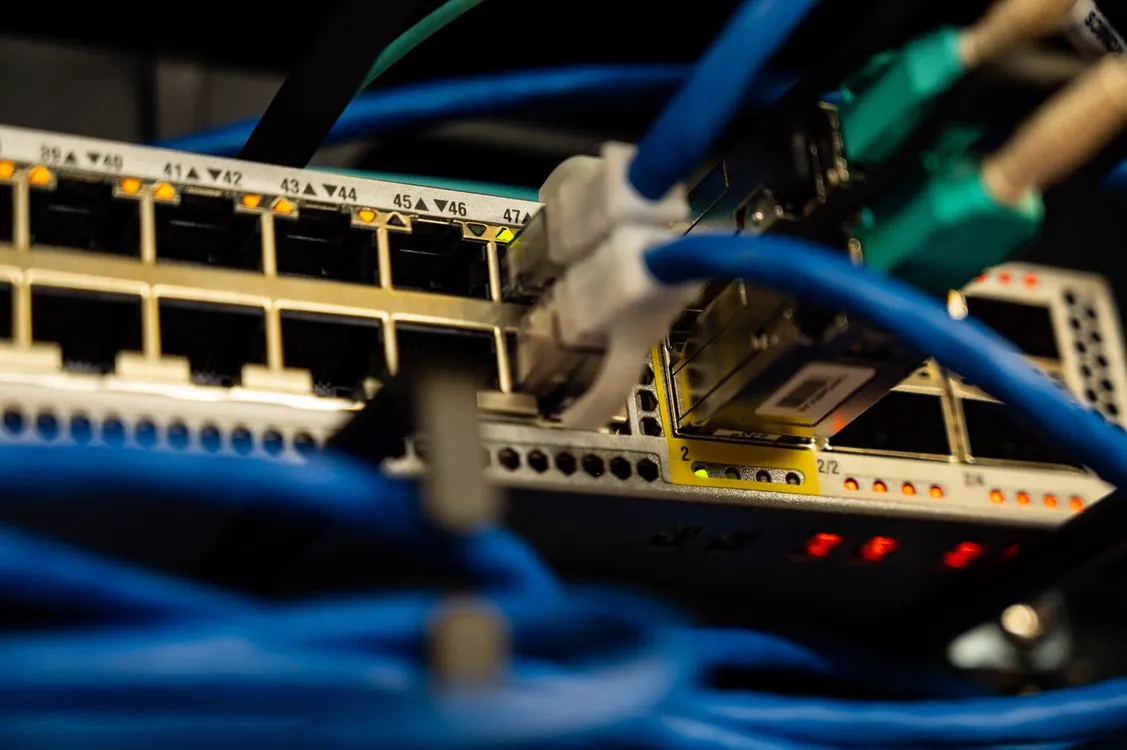 an ethernet cable connected to a high-speed router with speed test metrics on a digital display