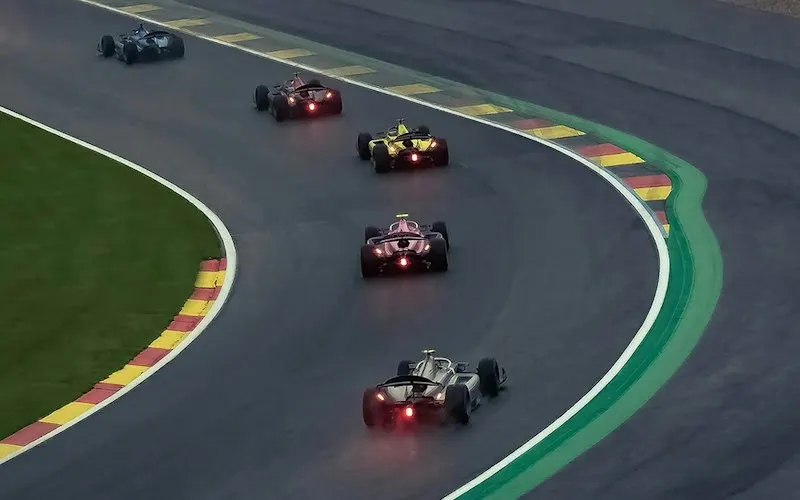 Racing cars speeding along a track in front of spectators