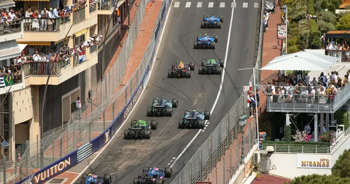 Formula-style race cars driving through a tight circuit corner