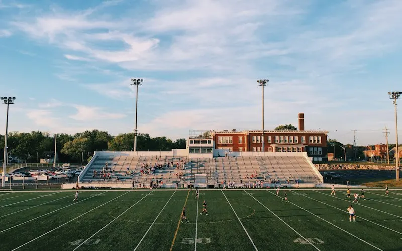 Football stadium stands and field under a cloudy sky