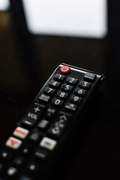 Siri Remote control device showing the touch surface navigation interface used for IPTV channel browsing and content control on Apple TV