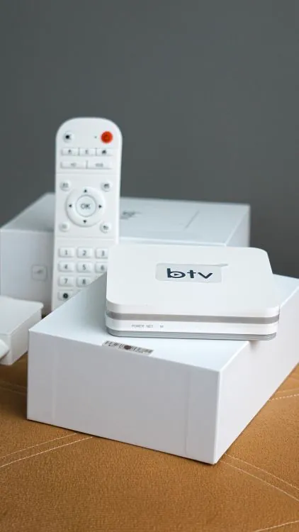 Modern smart TV control equipment with remote control and streaming device on a table for IPTV viewing